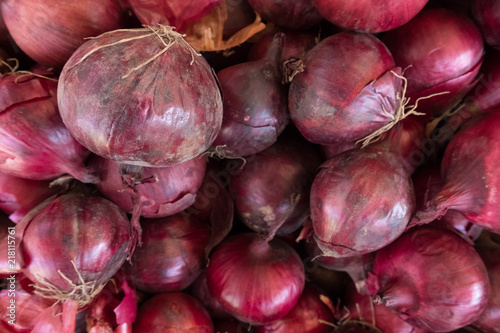 Fresh red onion stand at a street organic food market.