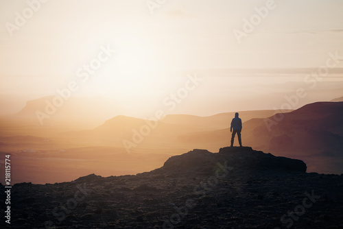 Tourist at sunrise in the mountains