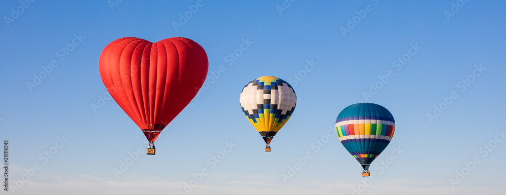 Fototapeta premium Red heart shaped and colorful air balloons flying in the sky
