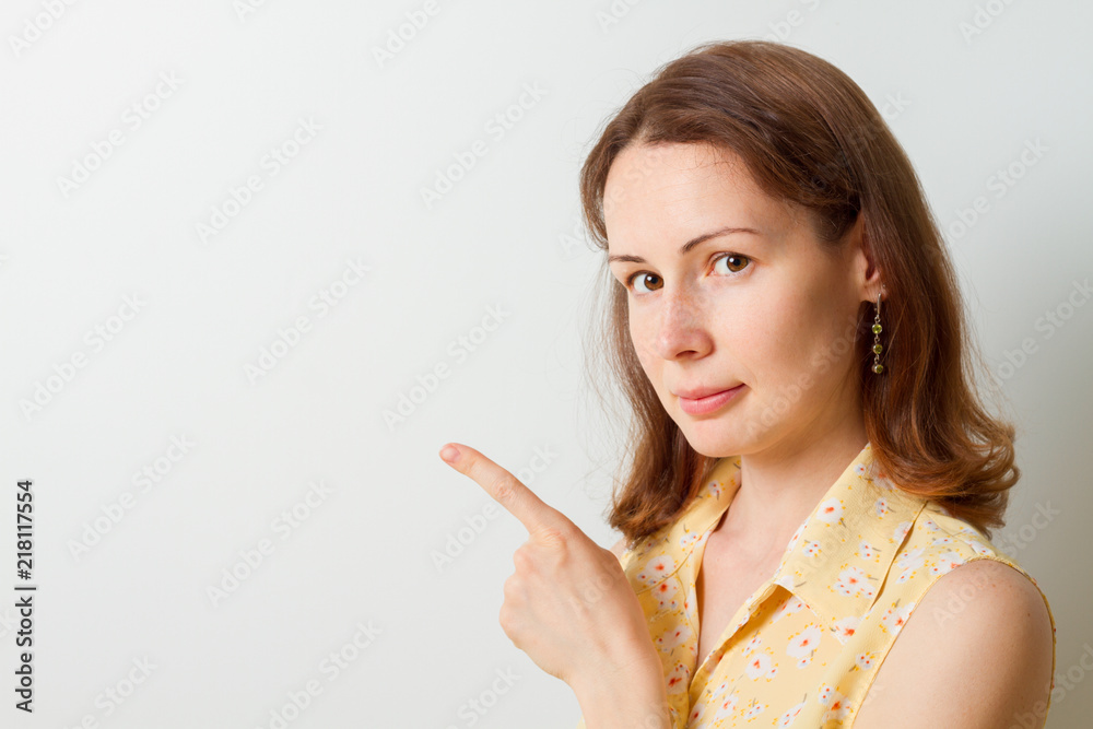 Portrait of a pretty girl pointing finger away isolated on a white background Portrait of a pretty girl pointing finger away isolated on a white background