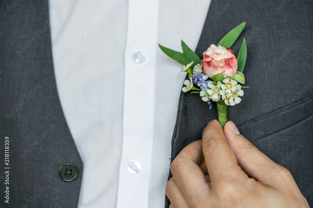 A small elegant wedding boutonniere on the waistcoat of a man. Male stylish festive image. A small elegant wedding boutonniere on the waistcoat of a man. Male stylish festive image.