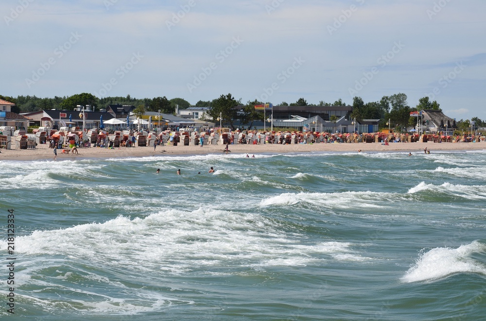 Menschen baden im Ostseebad Dahme im Meer bei hohen Wellen