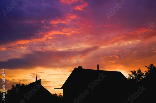 Silhouette of a house and the tree in the purple sunset