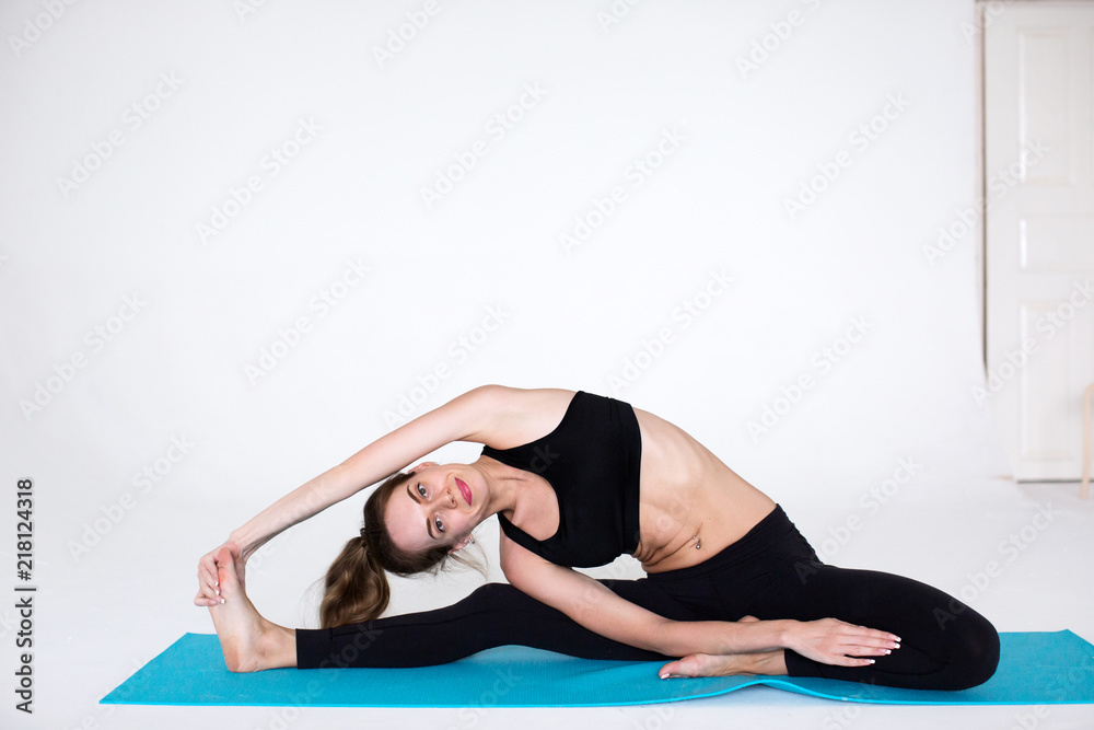 Flexible woman exercising on a fitness mat Flexible woman exercising on a fitness mat