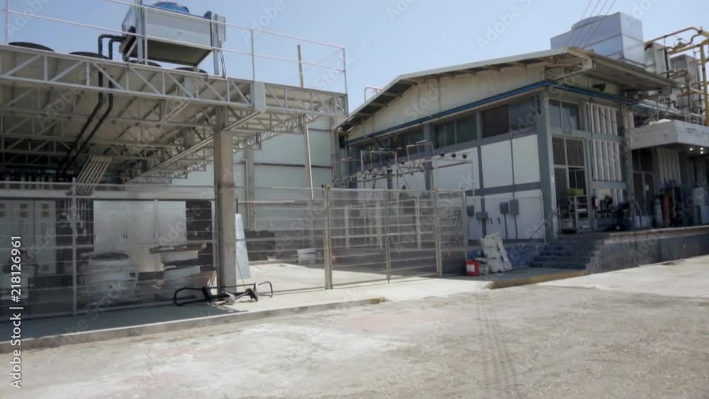 Pan Left outside an industrial gas factory, with work plants and trucks Pan Left outside an industrial gas factory, with work plants and trucks