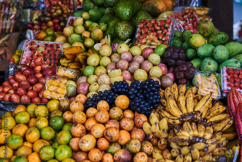 Asian exotic fruits. Market stall with variety of organic fruits. Colorful fruits in the marketplace. Bright summer background. Healthy  organic food. Natural nutrition for diet. Selective focus.
