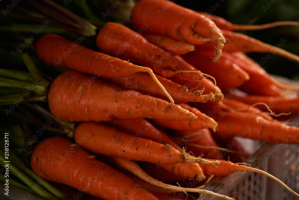 Realistic Carrots at a farmers market outdoors. Fresh organic produce on sale at the local farmers market. Realistic Carrots at a farmers market outdoors. Fresh organic produce on sale at the local farmers market.