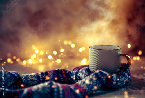 Winter coffee mug covered with wool scarf over bokeh lights photo