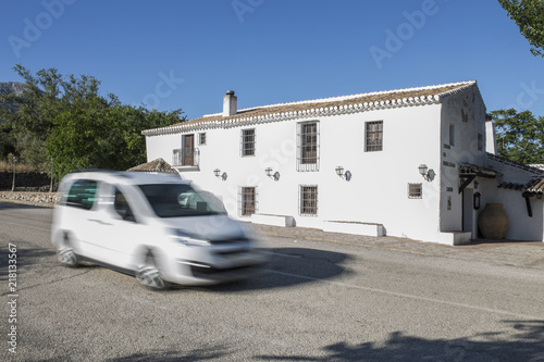 Fotografie Car crossing by Alfarnate hosterly, The oldest Andalusian inn active, Malaga, Sp