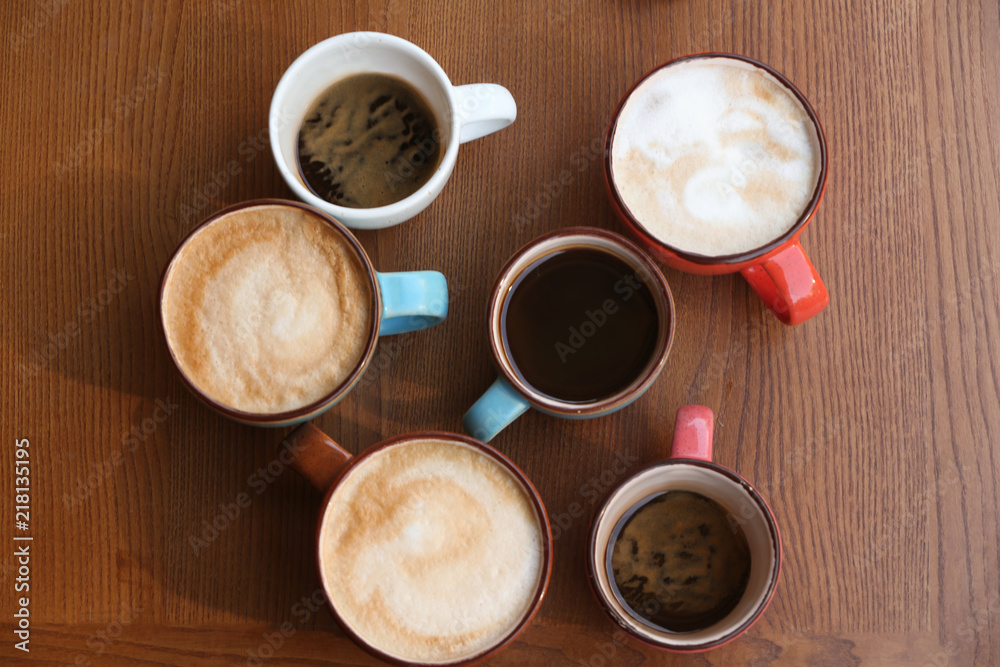 Cups of fresh aromatic coffee on wooden table, top view Cups of fresh aromatic coffee on wooden table, top view