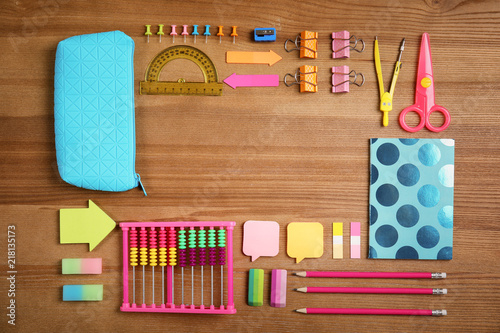 Different school stationery with space for design on wooden background, flat lay