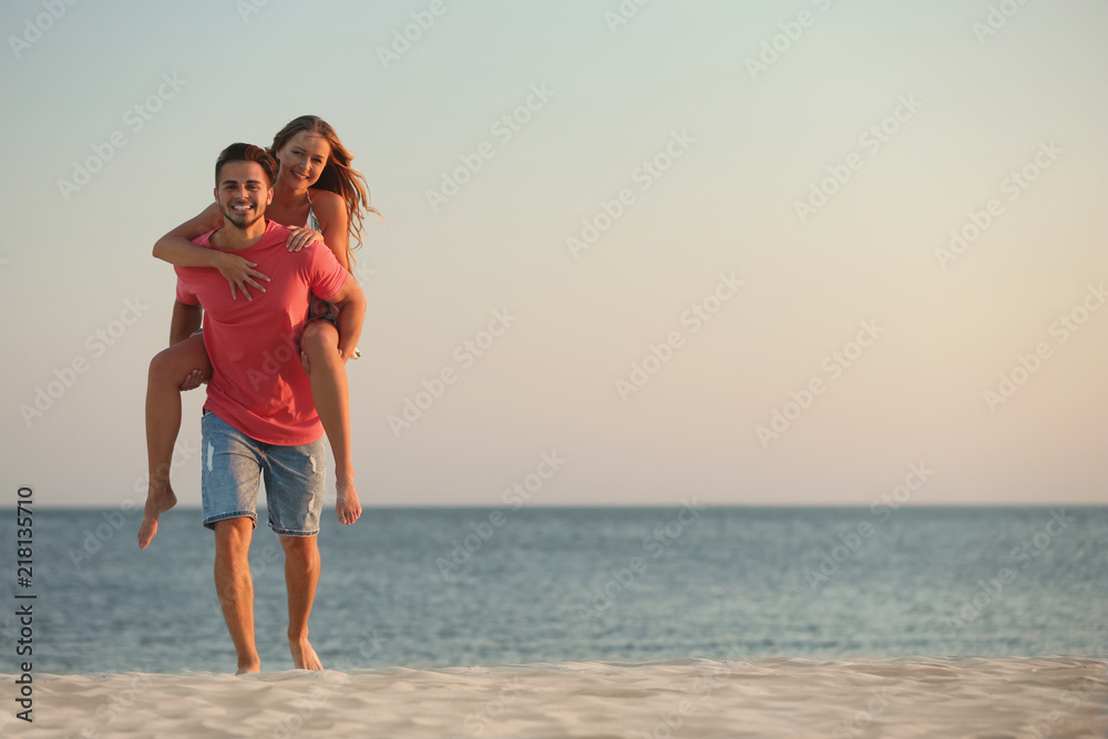 Happy young couple playing together on beach