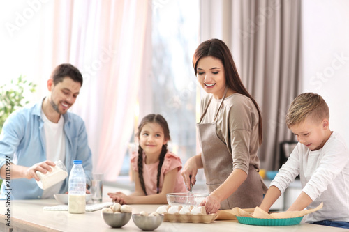 Happy family cooking pastries together in kitchen