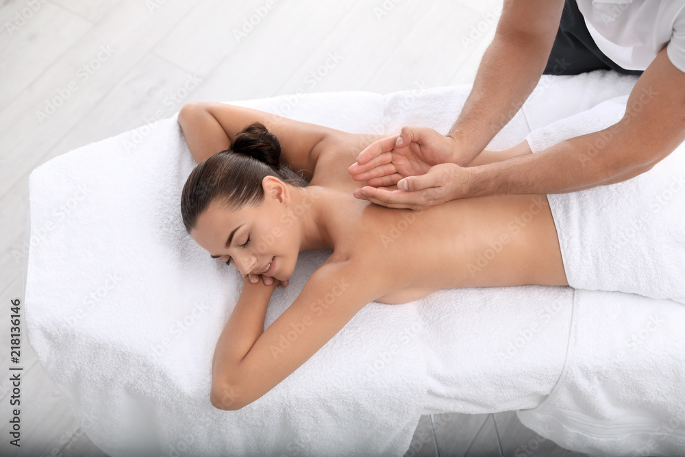 Relaxed woman receiving back massage in wellness center Relaxed woman receiving back massage in wellness center