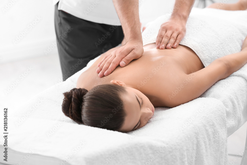 Relaxed woman receiving back massage in wellness center