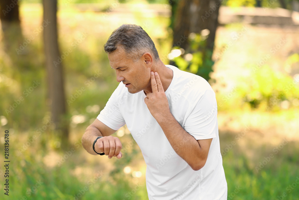 Man checking pulse outdoors on sunny day Man checking pulse outdoors on sunny day