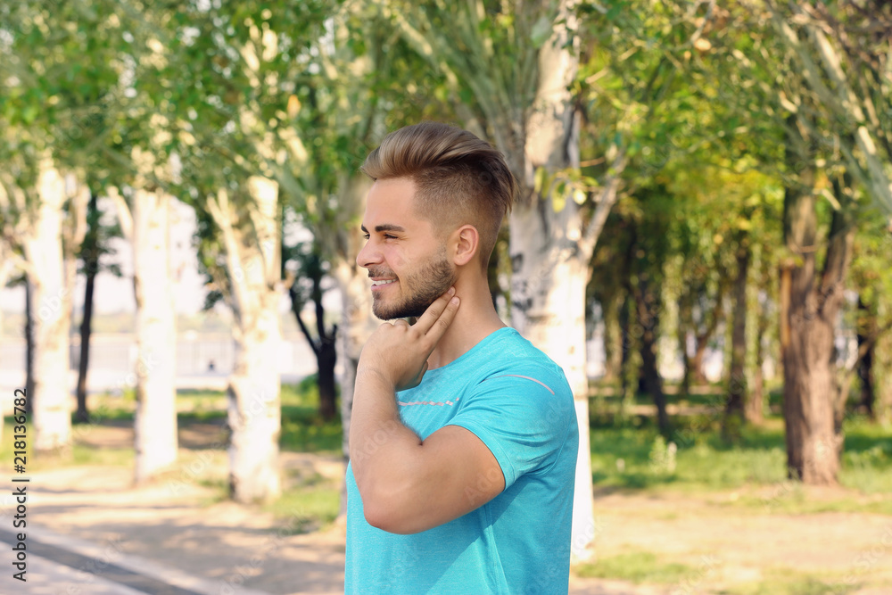 Young man checking pulse outdoors on sunny day Young man checking pulse outdoors on sunny day