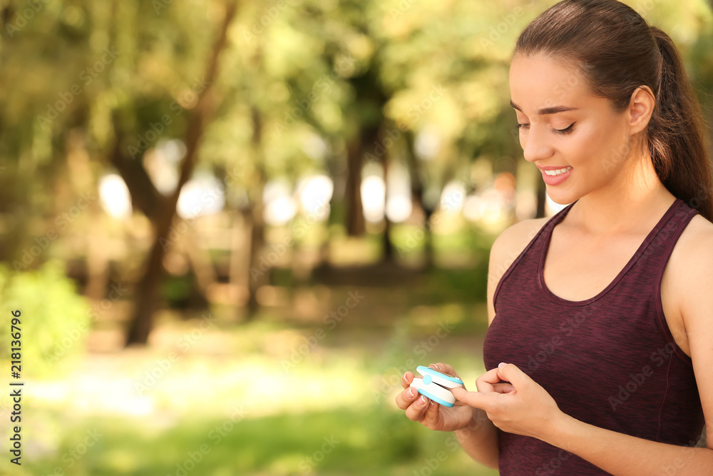Young woman checking pulse outdoors on sunny day Young woman checking pulse outdoors on sunny day