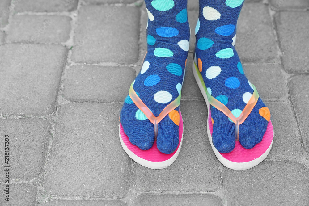 Woman wearing bright socks with flip-flops standing outdoors