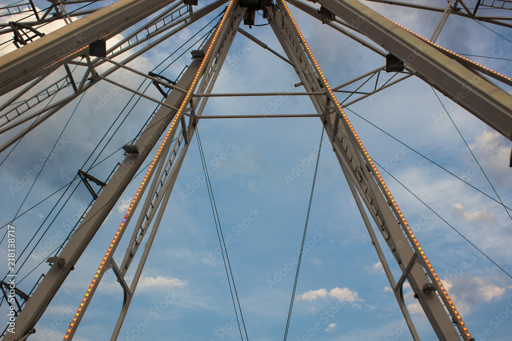 carnival entertainment concept of colorful shoot of ferris wheel metal construction element on blue sky background with empty space for copy or text carnival entertainment concept of colorful shoot of ferris wheel metal construction element on blue sky background with empty space for copy or text