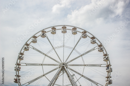 carnival entertainment concept of symmetry ferris wheel  construction object on cloudy gray sky background and empty space for copy or text