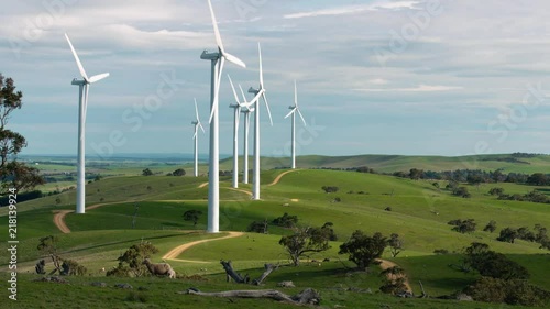 Multiple wind turbines spinning in Australian farmland.