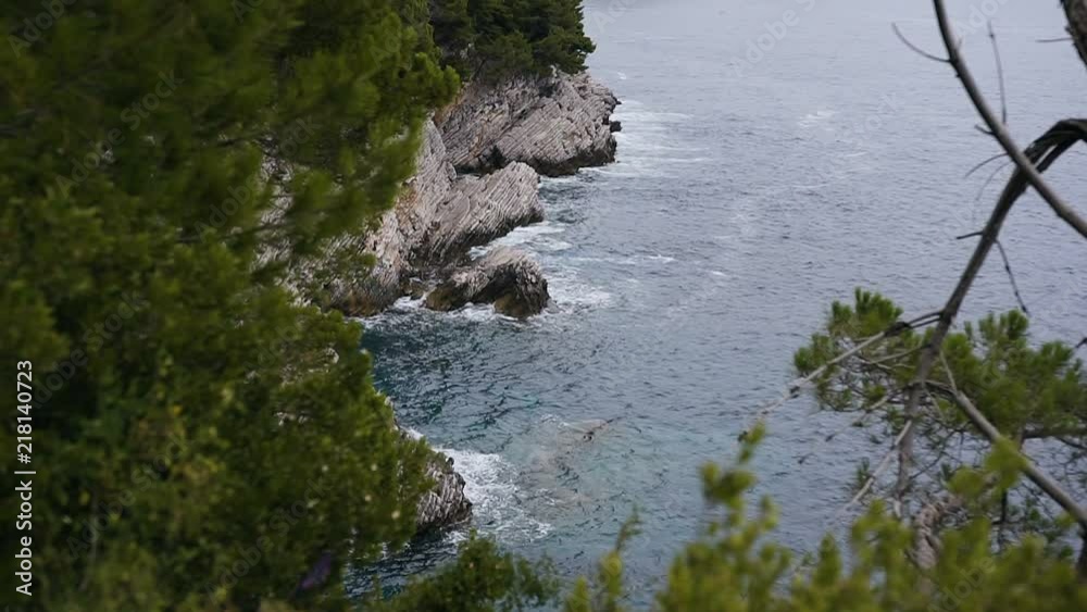 Adriatic sea and scenic layered rocks covered by pines at Petrovac. Montenegro Adriatic sea and scenic layered rocks covered by pines at Petrovac. Montenegro