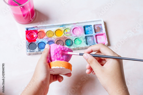 Watercolor palette with paintbrush in hand