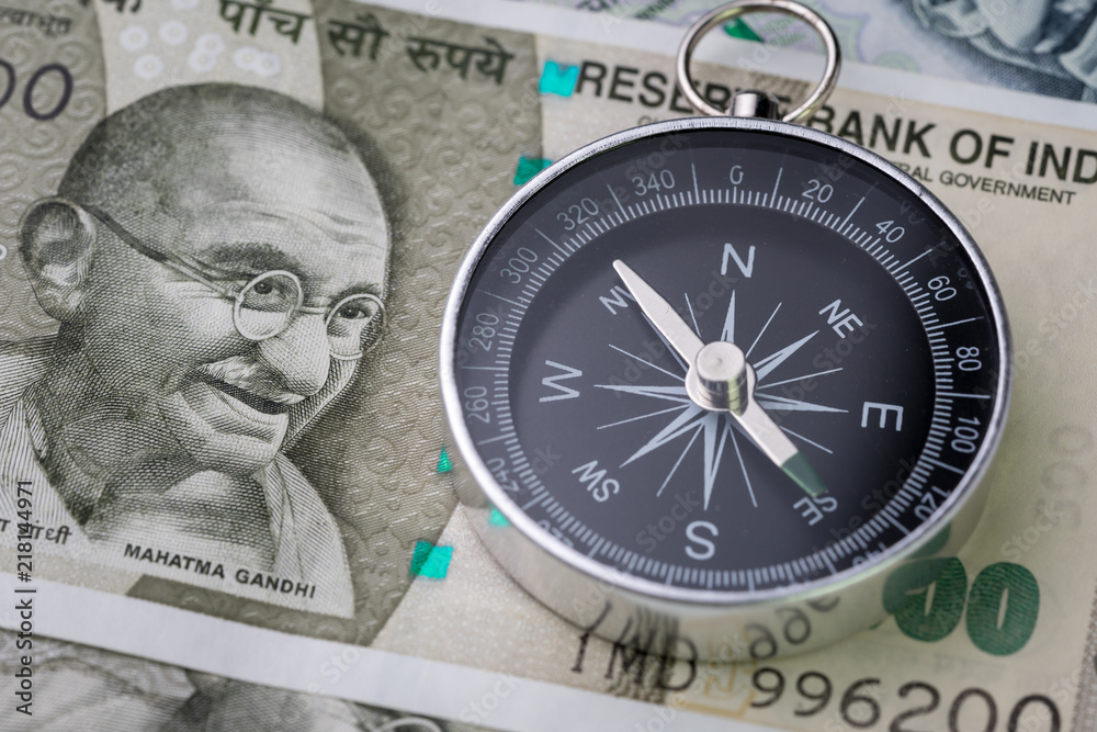 India financial and economy direction, new emerging market high growth country concept, closed up of compass on indian rupee banknotes on table India financial and economy direction, new emerging market high growth country concept, closed up of compass on indian rupee banknotes on table