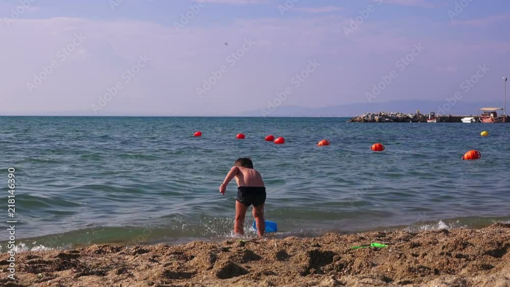 Little boy on a sea beach playing in the sand Little boy on a sea beach playing in the sand