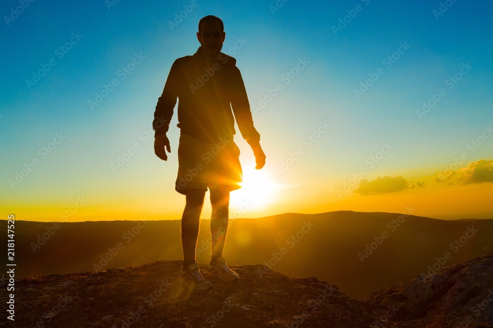 Man Standing on Rock Against Sun