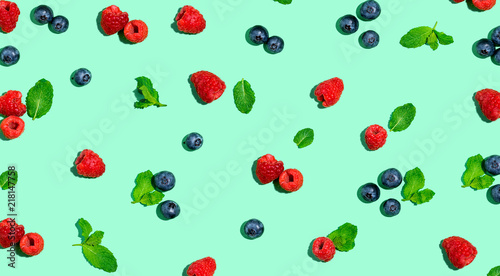 Blueberries and raspberries on a solid color background