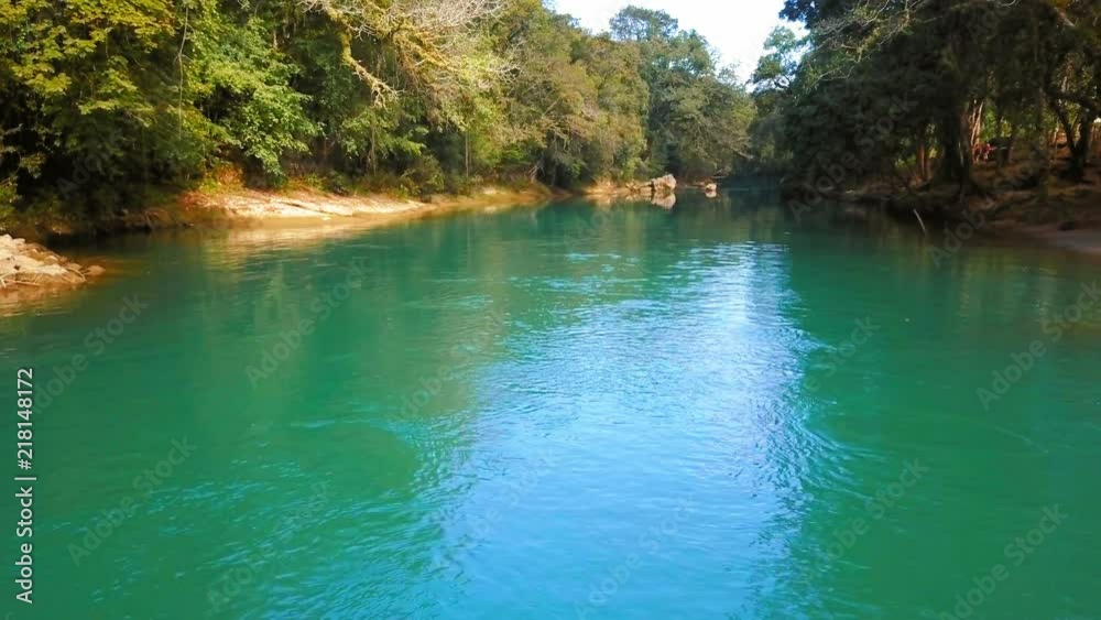 Flying Low over a turquoise river in the jungle of Guatemala, sunny day Flying Low over a turquoise river in the jungle of Guatemala, sunny day