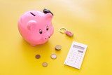 Mortgage. Savings for buy house. Moneybox in shape of pig near keychain in shape of car, coins, calculator on yellow background copy space