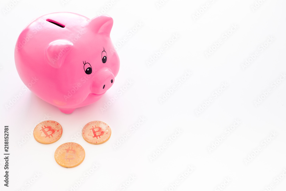 Savings. Moneybox in shape of pig near coins on white background copy space