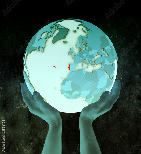 Portugal on blue globe in hands