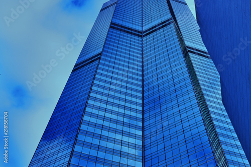 Business office skyscrapers, looking up at high-rise buildings in commercial district, architecture raising to the blue sky with white clouds, bottom view.