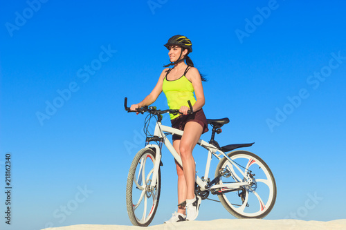 Woman on a bicycle against the blue sky
