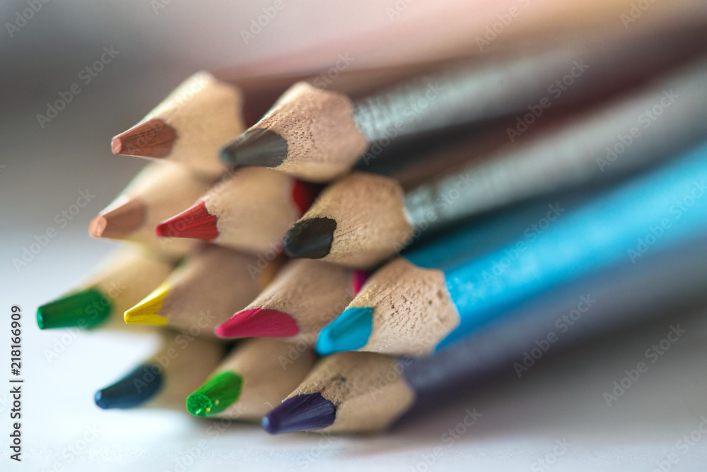 Obraz premium Pile of sharp coloured drawing pencils on table. Rainbow colors red, yellow, blue, green, purple. Concept of art, crafts and kids having fun