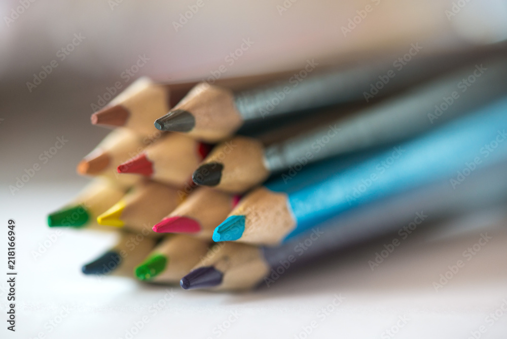 Pile of sharp coloured drawing pencils on table. Rainbow colors red, yellow, blue, green, purple. Concept of art, crafts and kids having fun Pile of sharp coloured drawing pencils on table. Rainbow colors red, yellow, blue, green, purple. Concept of art, crafts and kids having fun