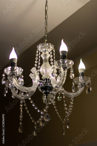 A crystal chandelier with candle-shaped bulbs hanging from the ceiling