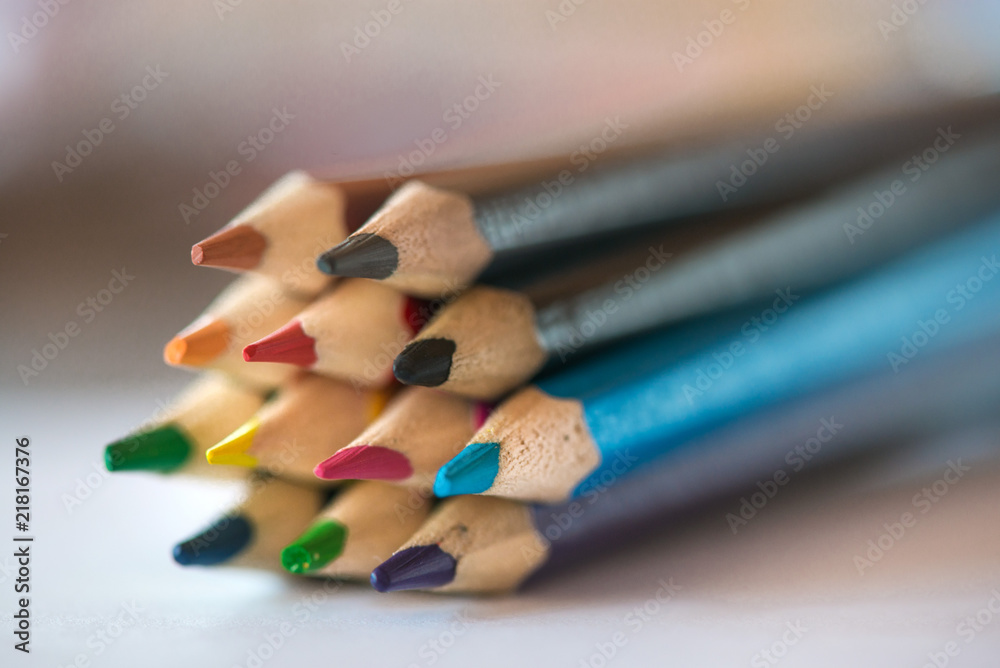 Pile of sharp coloured drawing pencils on table. Rainbow colors red, yellow, blue, green, purple. Concept of art, crafts and kids having fun Pile of sharp coloured drawing pencils on table. Rainbow colors red, yellow, blue, green, purple. Concept of art, crafts and kids having fun