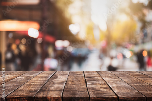 Empty wood table top on blurred with bokeh shopping mall on walking street background - can be used for display or montage your products