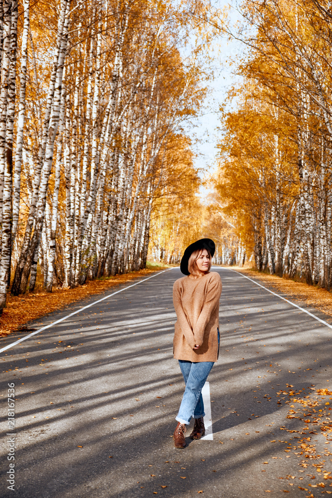 Portrait of an autumn woman over golden leaves. Woman walking in park at autumn season Portrait of an autumn woman over golden leaves. Woman walking in park at autumn season