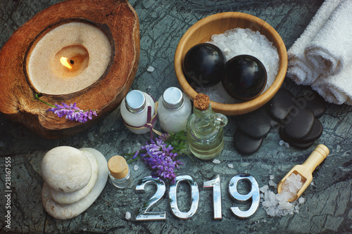 Set for spa procedures in 2019, bath salt and massage oil along with candles and white towels, there are also bian stones for massage