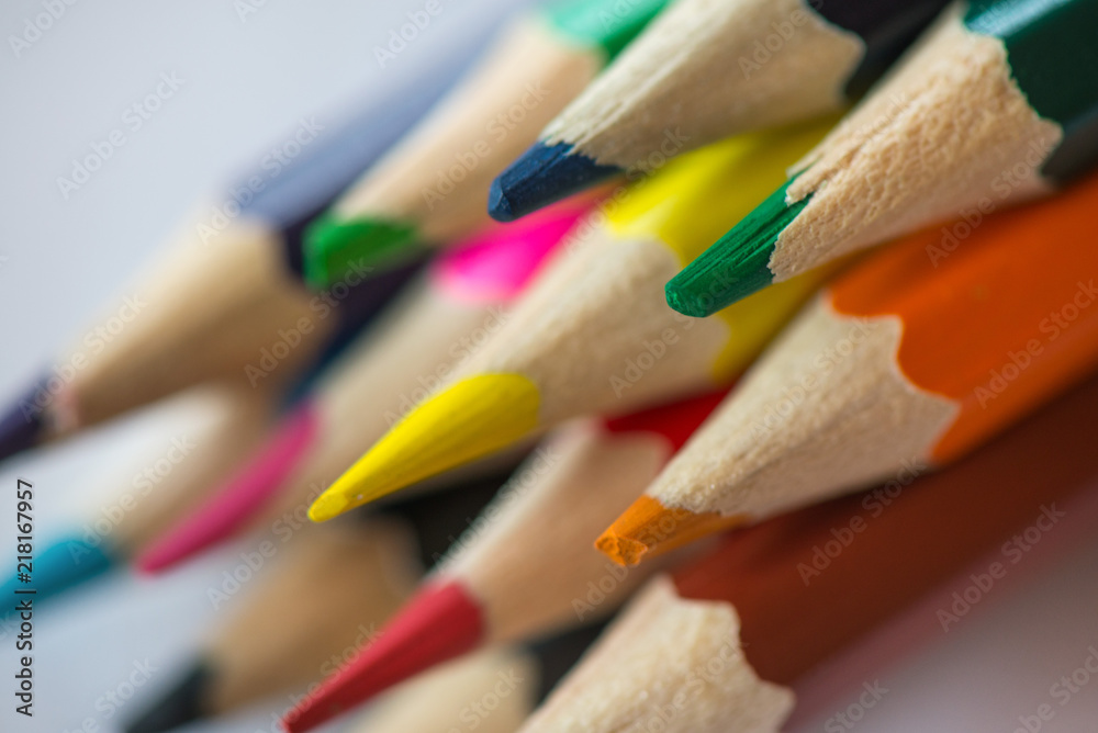 Pile of sharp coloured drawing pencils on table. Rainbow colors red, yellow, blue, green, purple. Concept of art, crafts and kids having fun Pile of sharp coloured drawing pencils on table. Rainbow colors red, yellow, blue, green, purple. Concept of art, crafts and kids having fun