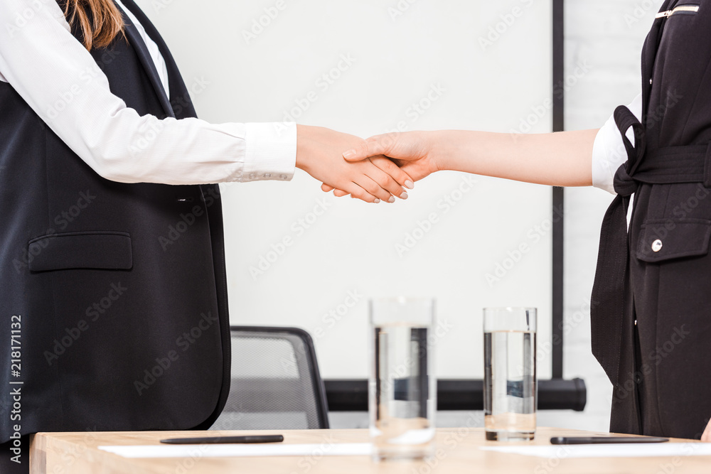 cropped shot of businesswomen shaking hands at modern office