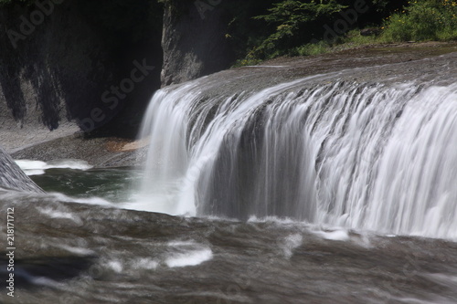 Fototapeta Naklejka Na Ścianę i Meble -  岩盤の割れ目へゆっくりと落ちる渓流