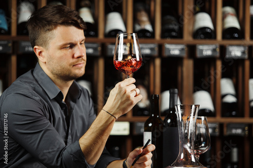 Sommelier looking at red wine glass with beverage