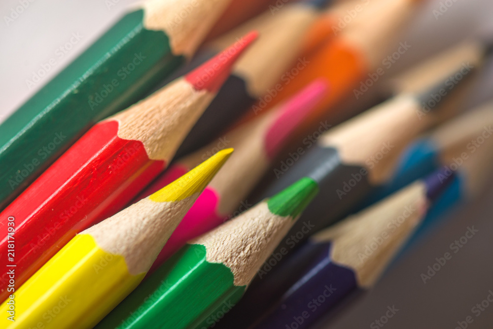 Pile of sharp coloured drawing pencils on table. Rainbow colors red, yellow, blue, green, purple. Concept of art, crafts and kids having fun Pile of sharp coloured drawing pencils on table. Rainbow colors red, yellow, blue, green, purple. Concept of art, crafts and kids having fun